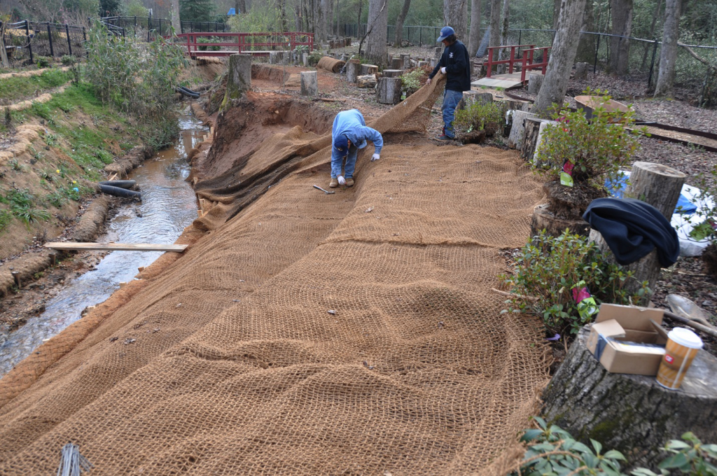 Contractors installing soil erosion control mats